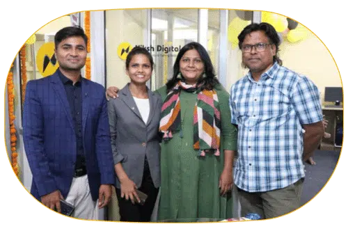 group photo -in this image with 4 person's in the background niksh digital marketing agency logo on the glass