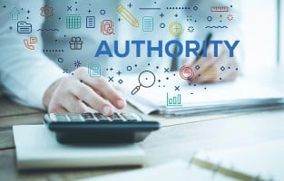 A person using a calculator surrounded by icons and the word “Authority,” highlighting the importance of being a credible and knowledgeable source