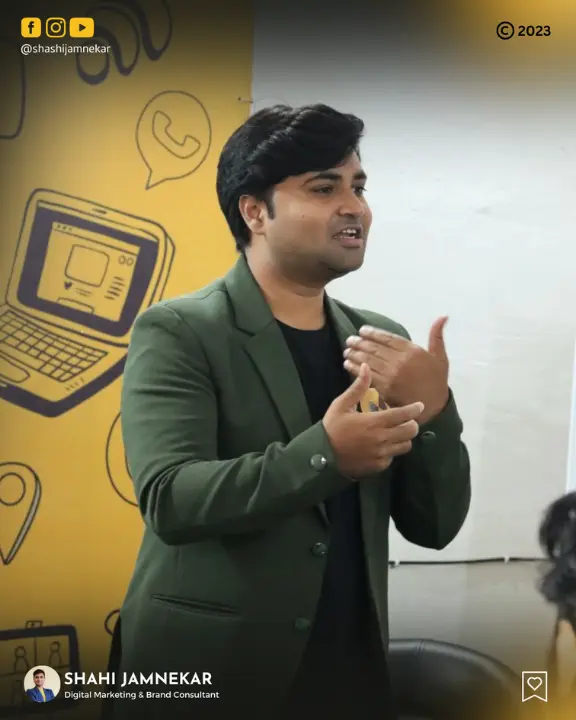 Professional shot of Shashi Jamnekar, a Digital Marketing & Brand Consultant, presenting at a seminar against a branded yellow background with social media icons.